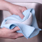 Cleaning a bowl by hand with a blue waffle-weave towel 
